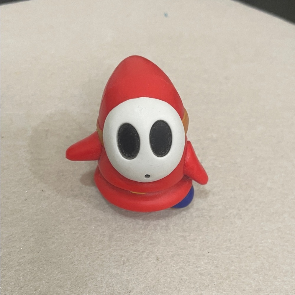 Red Hooded Character Figure/Shy Guy from the Super Mario Bros. universe.